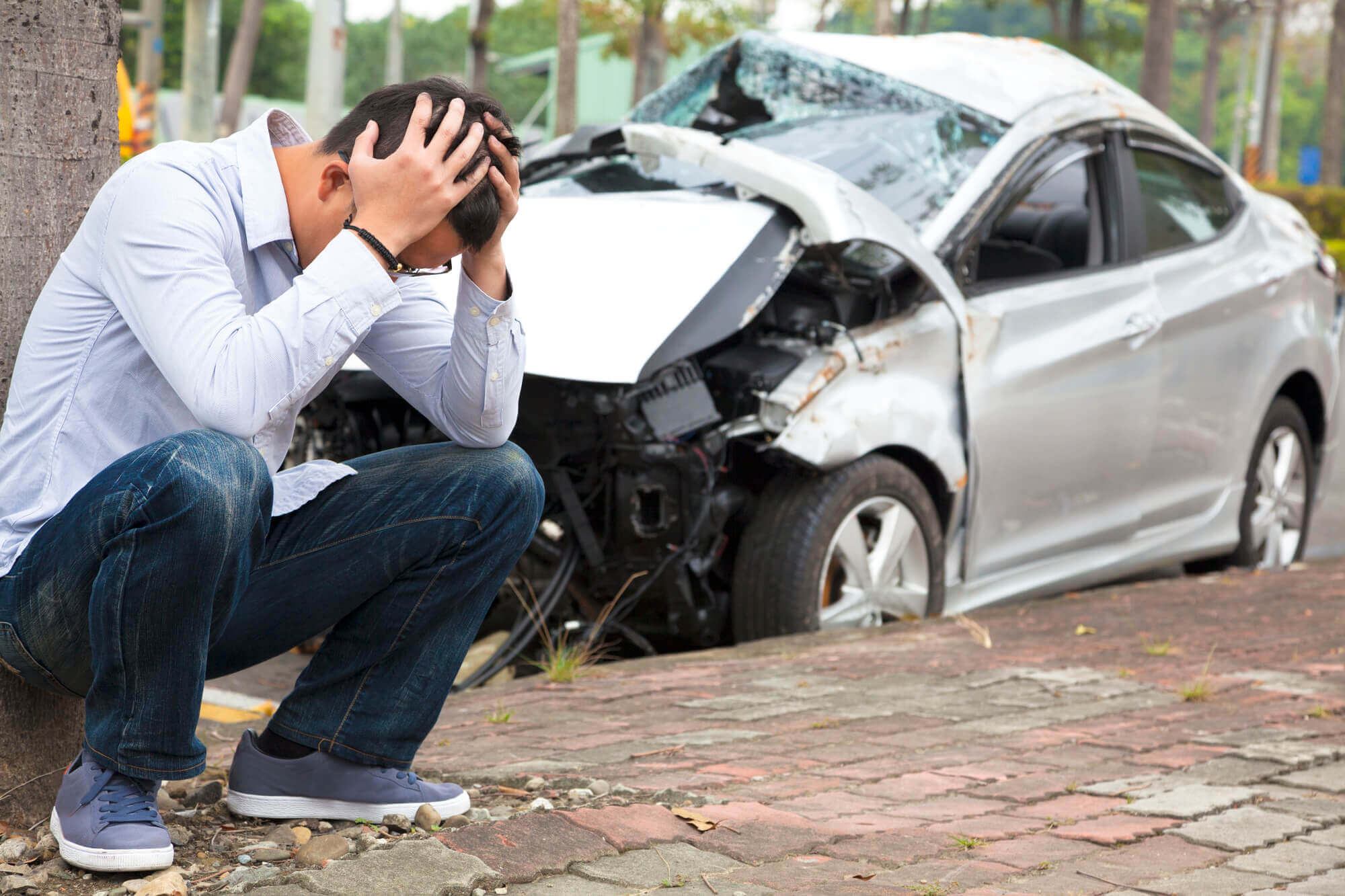 Hombre estresado por un accidente de auto antes de llamar a un Abogado de accidentes de tránsito en Miami
